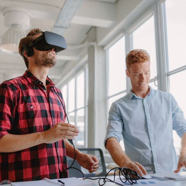 Young developer working on laptop and virtual reality glasses. 