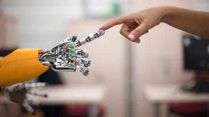 A human hand connecting with a robot in a laboratory.