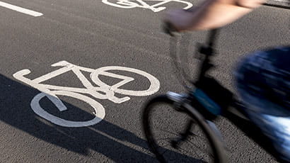 Cyclist commuter wearing a pollution-mask in Central London, while commuting to work in the morning.