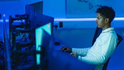 Person using a computer in a blue lit room.