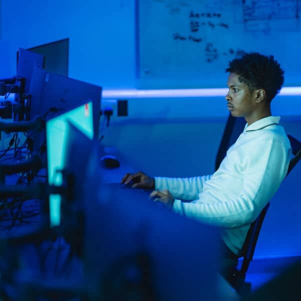 Person using a computer in a blue lit room.
