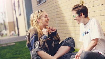 A couple of students laughing outside their accommodation.