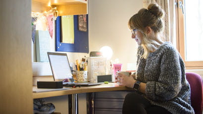 Student sat at desk in student accommodation