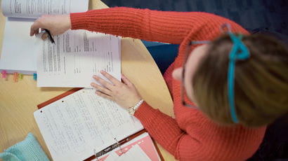 Aerial view of a student writing on a notepad