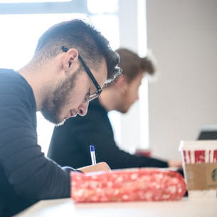 Students writing in a study room.