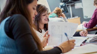 Two students writing at a desk