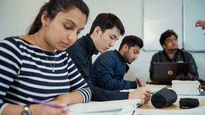 Students writing at a desk