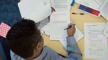 Aerial photograph of a student writing in an exam paper