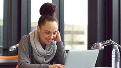 Female student sat in front of a laptop.