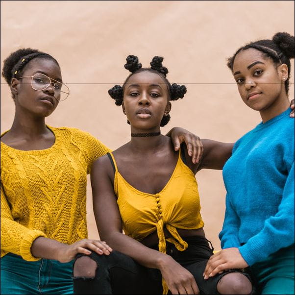 Three black students pose together for a photograph
