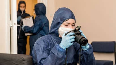 Person in forensic gear taking photos.