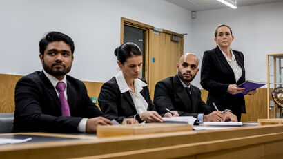 Solicitors at the bar in a courtroom.