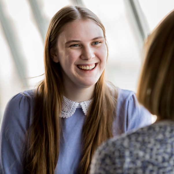 Student talking to another person and smiling.