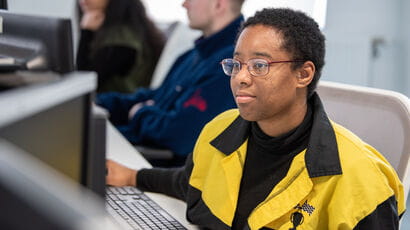 A student using a computer in the library to study.