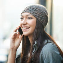 Female smiling while having a conversation on a smartphone