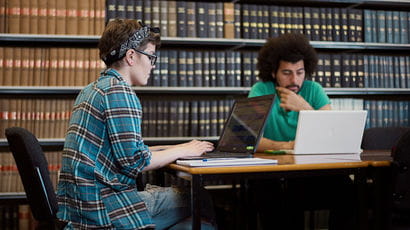Students working on laptops in campus library