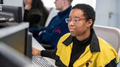 Three students using computers on Frenchay Campus