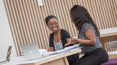 Two students working on laptop