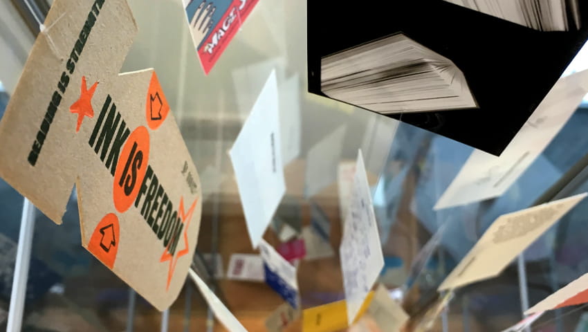 Display of artists' bookmarks in a glass cabinet.
