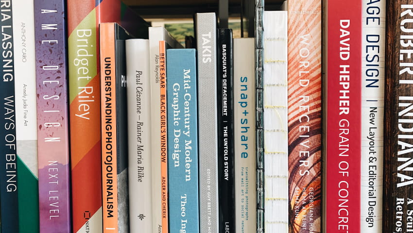 Photograph of the spines of books on a shelf.