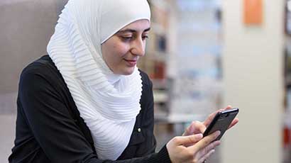 A student looks at her phone to find out her PIN.