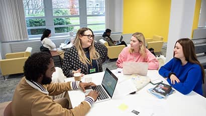 Staff and students talking in the library.