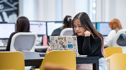 Student working on a laptop in a study space