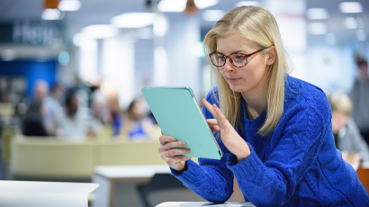Student reading tablet screen.