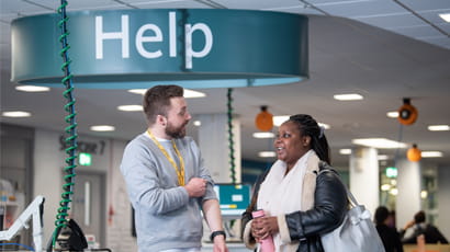 Library staff and student at library help desk