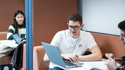 Student working on a laptop in a study space
