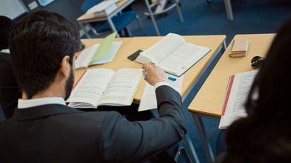 Student looks at his books while studying
