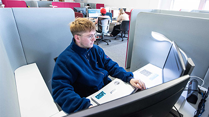 Student working on computer in a silent study pod