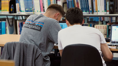 Two students studying in the library.