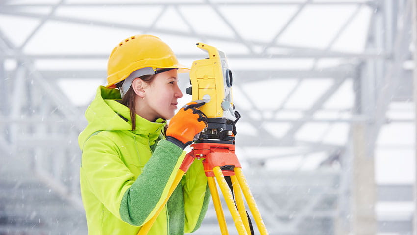 A student in protective gear surveying a construction site