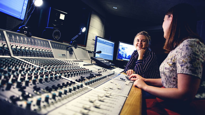 Two students working together in a recording room 