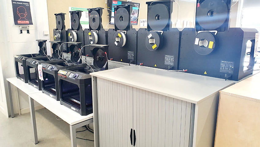 Two rows of 3D printers ready to use
