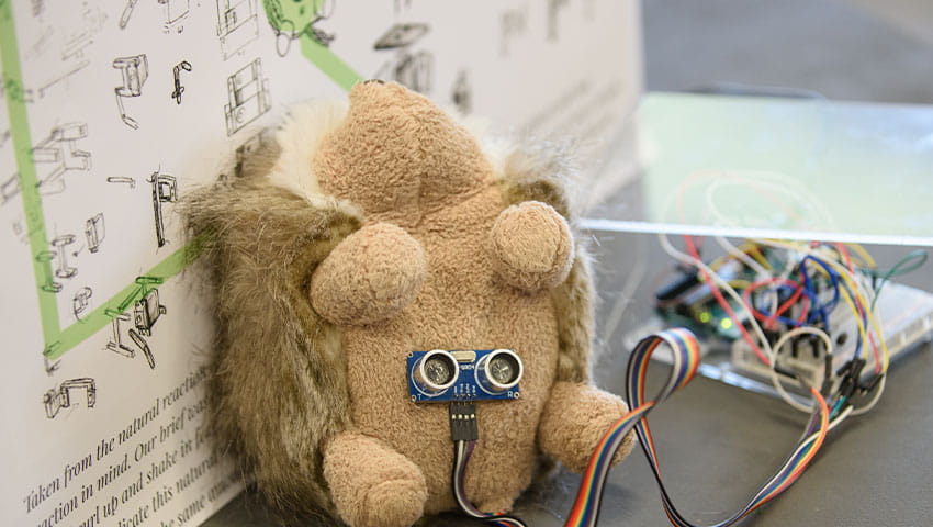 A stuffed hedgehog with electrical wire on its stomach connecting to a circuit board