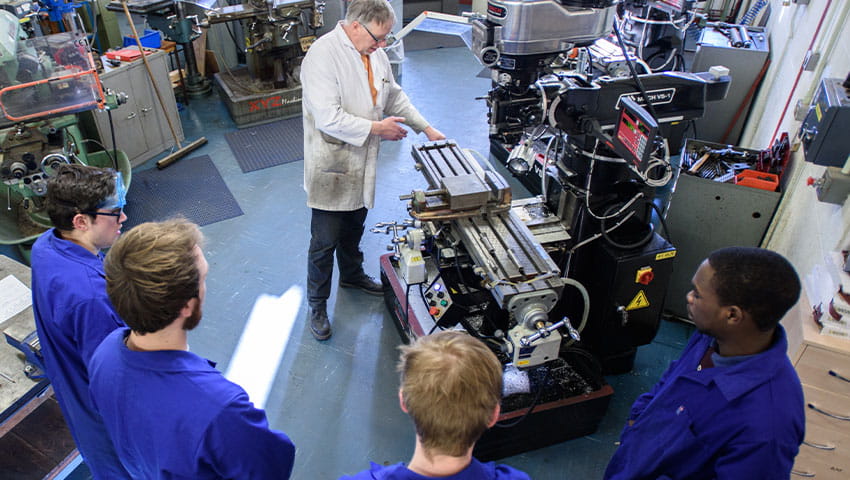 Five students and an instructor in a fabrication workshop