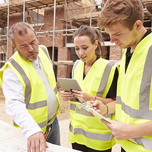 Students wearing high-vis jackets at a construction site.