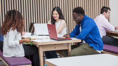 Group of students working on laptops at the Business School.