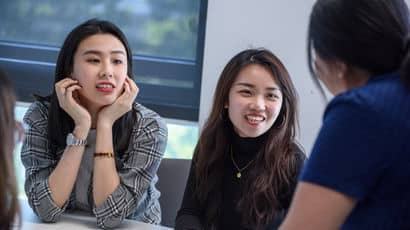 Group of students working in a meeting room.