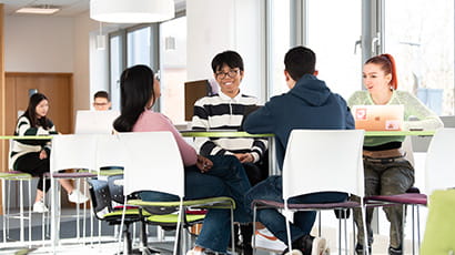 Group of students sat at a table in a study lounge