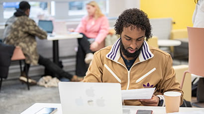 Student reading notes in a study lounge