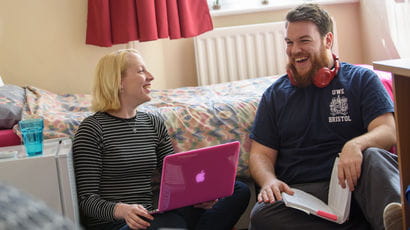 Two students laughing together in university accommodation
