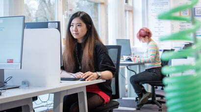 Students working at computer desks in the library.