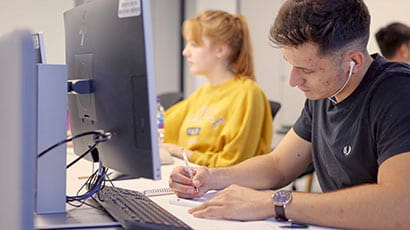 Two students using computers in a study area
