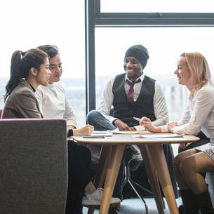 Group of people attending a meeting at a table.