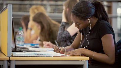 students completing work in the library