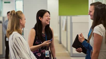 Four placement students stood in an Intel office laughing and talking