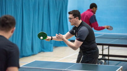 Young man playing table tennis serving the ball.